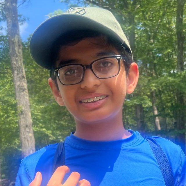 Portrait of Krish Soni wearing glasses and a green cap
